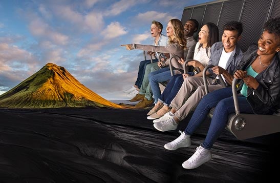People on a flight ride superimposed over a scene of a rocky point at the sea.