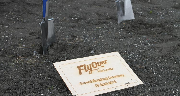 Shovels stick out of the ground at the FlyOver Iceland groundbreaking plaque.