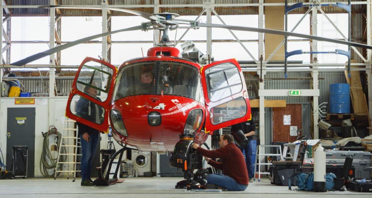 Workers fit the FlyOver Iceland helicopter in a hangar.