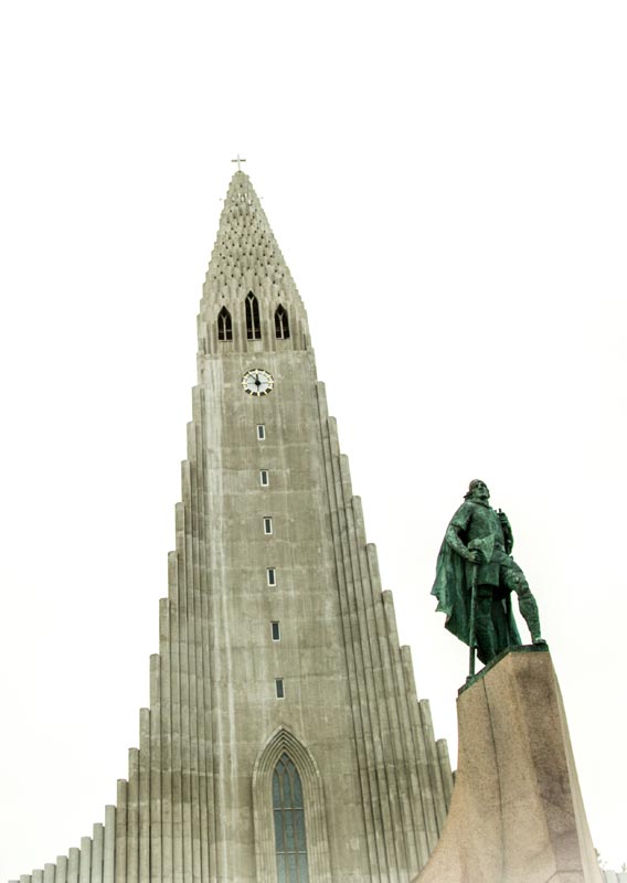 A statue of Leif Erikson in front of Hallgrímskirkja, a large stone cathedral.