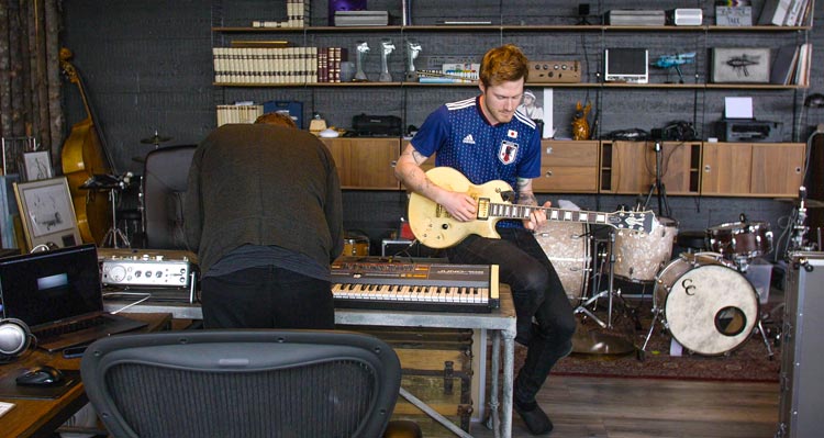 a man plays the electric guitar in a music studio
