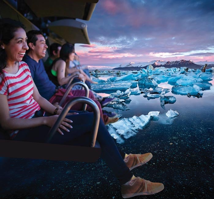 View of guest on FlyOver ride shows spherical screen and legs hanging from chairs