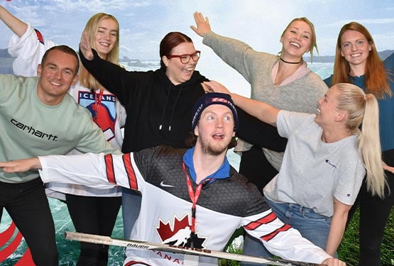 A group of people pose with "airplane wings" for a photo.