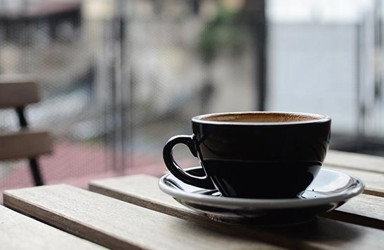 A coffee cup on a small wooden table.