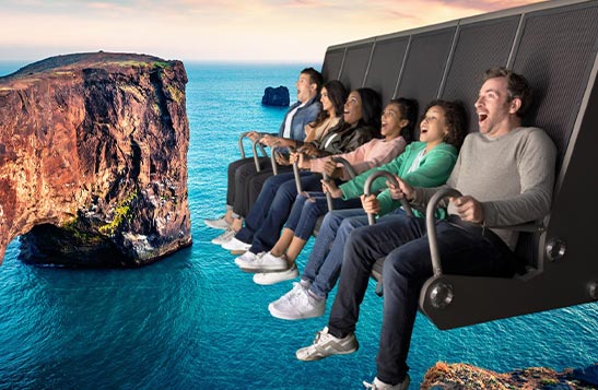 A group of people sit on a flight ride superimposed over an ocean scene.