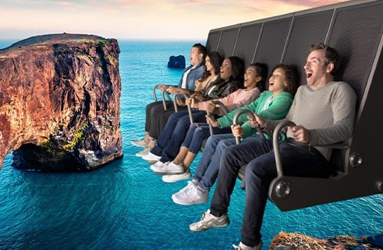 A group of people sit on a flight ride superimposed over an ocean scene.