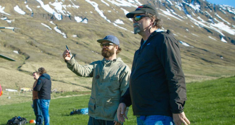 Two people gesture their vision of a scene in a wilderness setting.