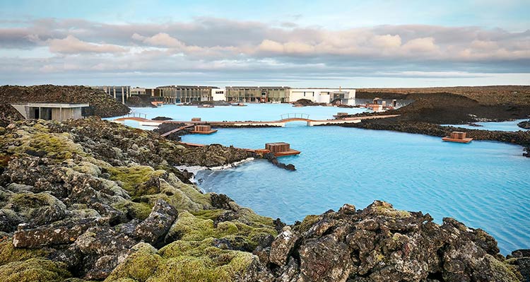 The Blue Lagoon hot springs of blue pools and spa buildings in a rocky landscape.