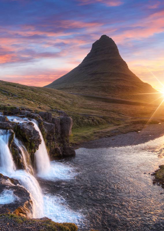 The Kirkjufellfoss waterfall in front of the mountain Kirkjufell.