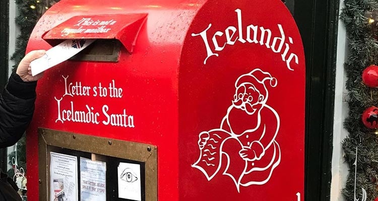 A letter being put into a mailbox for Santa