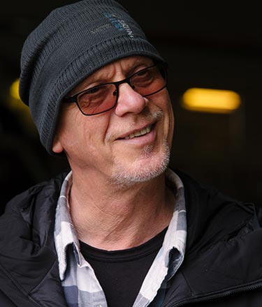 A man with sunglasses and a winter hat.