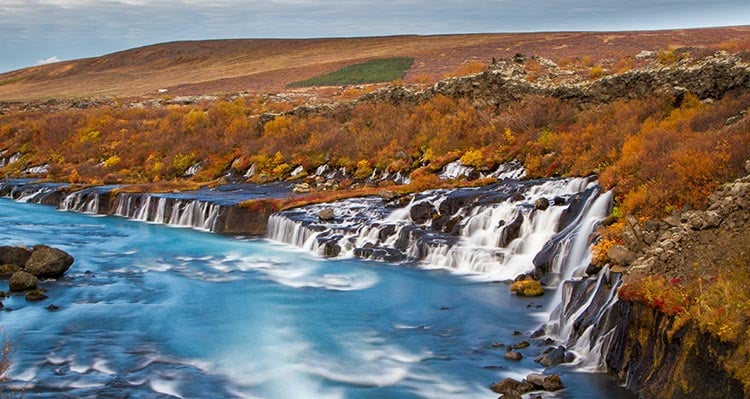 The waterfall Hraunfossar. A series of small waterfalls between a wide river and its continuation.