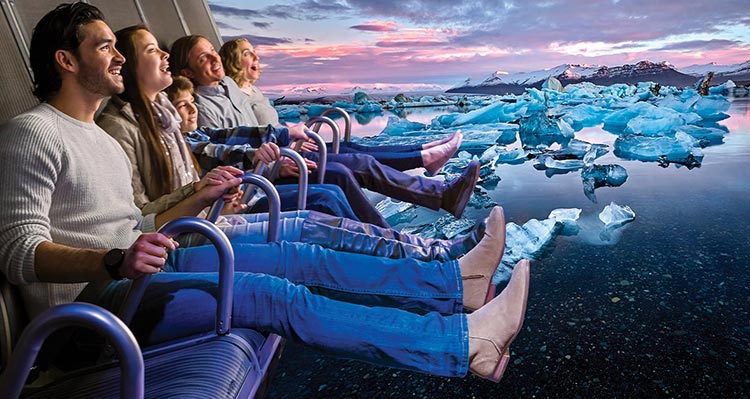 A group of people sit in excitement on the FlyOver Iceland flight-ride.